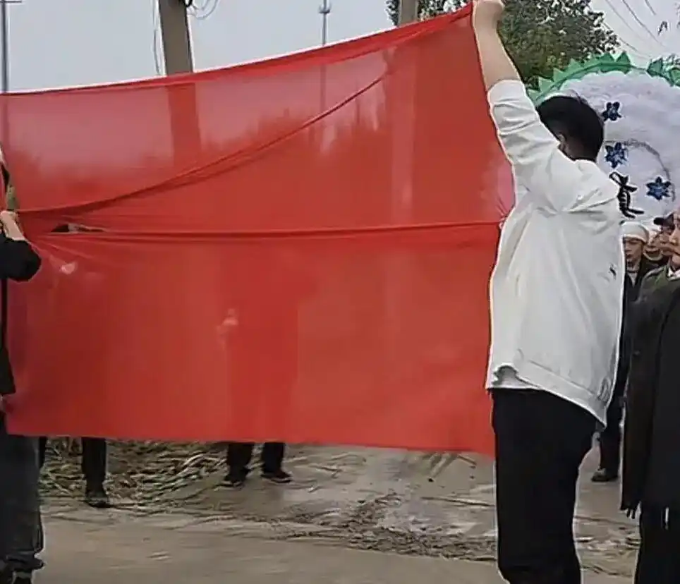 河南焦作红白事路口相逢拉起红布让婚车先行，白事主家回应：当地习俗“红让白”，但红事是一辈子的事，让新人先过去